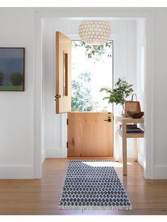 an entryway with a blue rug and wooden door