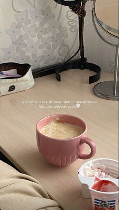 a cup of ice cream sitting on top of a table next to a container of yogurt