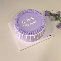 a birthday cake with purple icing and flowers on the side that says happy birthday