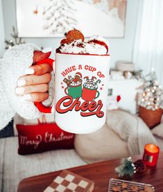 a person holding a coffee mug with christmas decorations on it