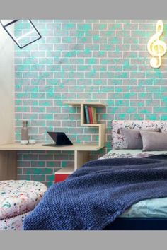 a bedroom with a bed, desk and bookshelf next to a brick wall