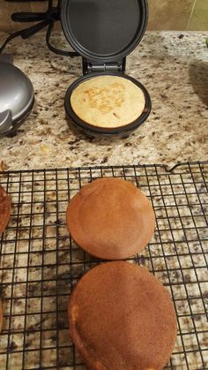 three pancakes sitting on top of a cooling rack next to an electric griddle oven