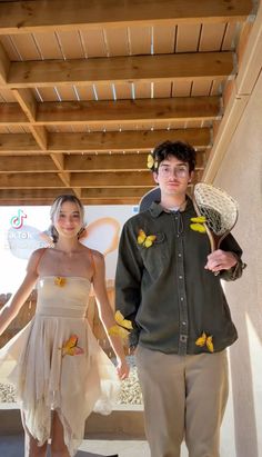 a man and woman standing next to each other holding tennis racquets