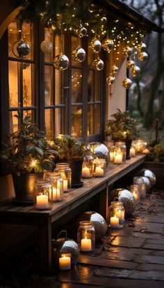 many lit candles are lined up in front of a window with potted plants on the windowsill