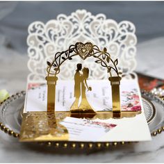 a gold and white wedding cake topper on a plate