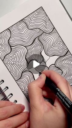 someone is drawing on paper with a marker