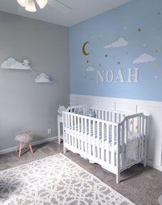 a baby's room with a white crib and blue walls