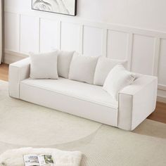 a white couch sitting on top of a rug in a living room