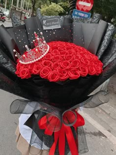 a large bouquet of roses with a tiara on top