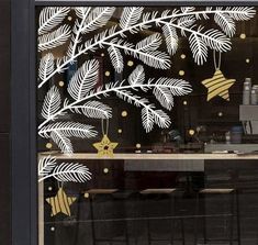 the window is decorated with white and gold decorations, including pine cones and bells on them