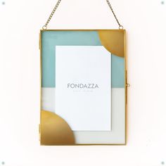 a white and gold frame hanging on a wall with the word fonddazza written in it