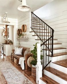 a living room filled with furniture and a stair case next to a wooden flooring