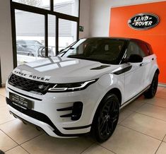 a white range rover parked in a showroom