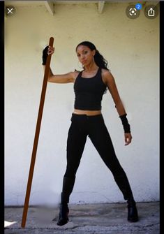 a woman is holding a stick and posing for the camera