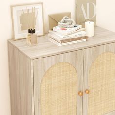 a wooden cabinet with some books on top of it next to a vase and other items