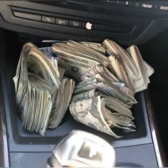 a pile of money sitting in the center console of a car