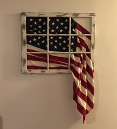 an american flag is hanging on the wall next to a window with bars in it