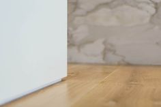 a white refrigerator sitting on top of a wooden floor