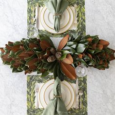 two place settings with napkins, plates and flowers on them are laid out in front of each other