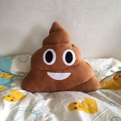 a stuffed poop sitting on top of a bed