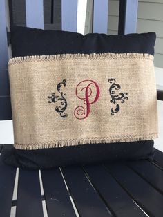 a pillow with the letter p on it is sitting on a wooden bench next to a chair