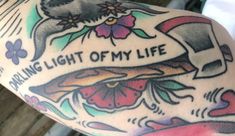 the back of a woman's arm with tattoos on it and words that read, daring light of my life