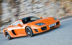 an orange sports car driving down the road