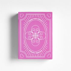 a pink playing card sitting on top of a white wall