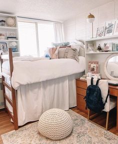 a bedroom with a bed, desk and mirror