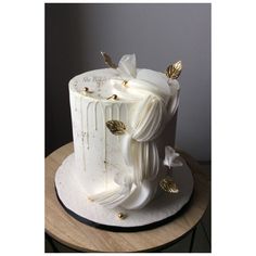 a white cake with gold leaf decorations on top