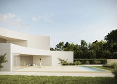 a person standing in front of a white building with a pool and trees behind it