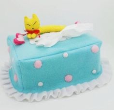 a blue cake with white polka dots and a yellow toy laying on top of it