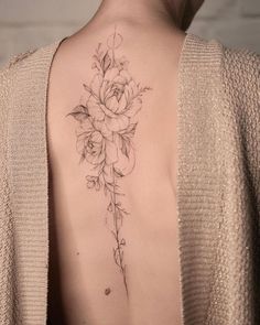 a woman with a flower tattoo on her back