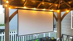 an outdoor covered patio with lights on the ceiling