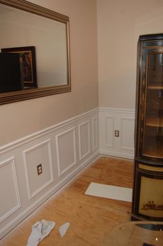 the corner of a room that is being remodeled with white paint and wood flooring