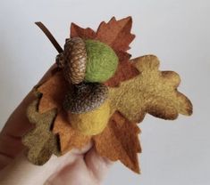 a hand holding a small felt fall decoration