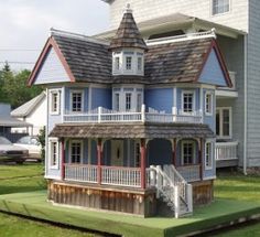 a doll house sitting on top of a green lawn