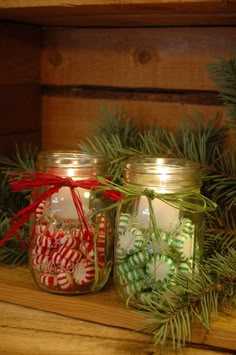 two mason jars filled with candy canes and christmas decorations