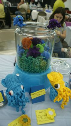 there are many crocheted animals in the vase on the table with name tags