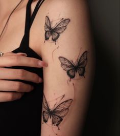 a woman's arm with three butterfly tattoos on the back of her left arm