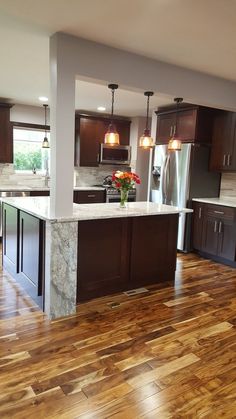 a kitchen with wooden floors and stainless steel appliances