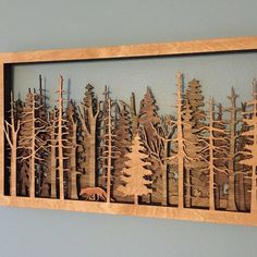 a wooden cut out of trees with a bear in the woods on it's side