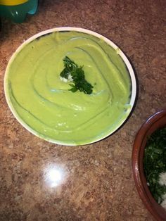 a white plate topped with guacamole next to a bowl filled with rice