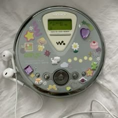 an electronic device with many stickers on it's face and headphones attached