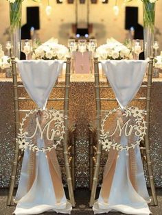 two gold chairs with white table cloths and flowers on the back are set up for a wedding reception