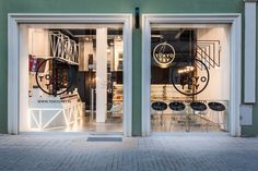 the front entrance to an artisan shop with glass doors that have black and white designs on them