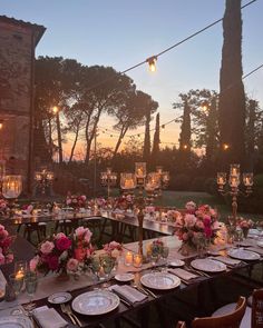 an outdoor dinner setup with candles and flowers