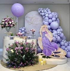 there is a table with flowers and balloons in the background that have been set up for a princess party