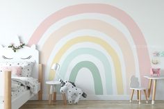 a child's bedroom with a rainbow wall mural