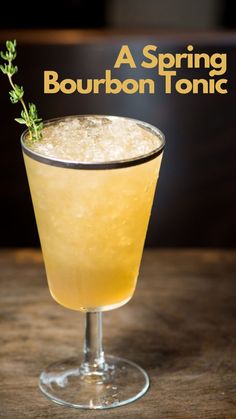 a glass filled with a drink sitting on top of a wooden table